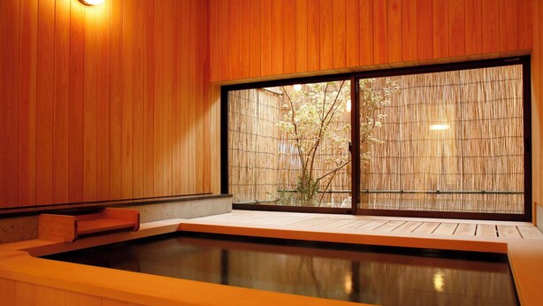 A wooden interior with a large window, a wooden bench, and a small pool. - Hanamandara (Toyooka)