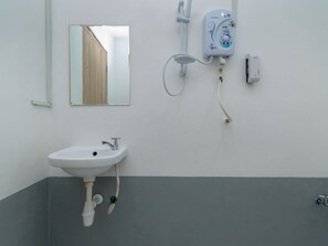 Un baño con un lavabo blanco, un espejo y una ducha empotrada.