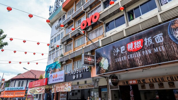 A multi-story building with various signs, including one for 'MADSUIITE' and another for 'SABAH CHI'. - OYO 43993 Madsuite (Kota Kinabalu)