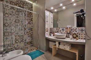 A bathroom with a shower, a sink, and a mirror. - Casa D'Angiò (Manfredonia)