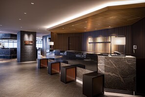 A modern reception area with a marble counter, wooden accents, and a reception desk.