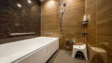 A modern bathroom with a large bathtub, a shower, and a toilet.