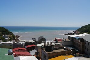 A coastal town with buildings overlooking the beach. - Mayu Hotel (Nangan)