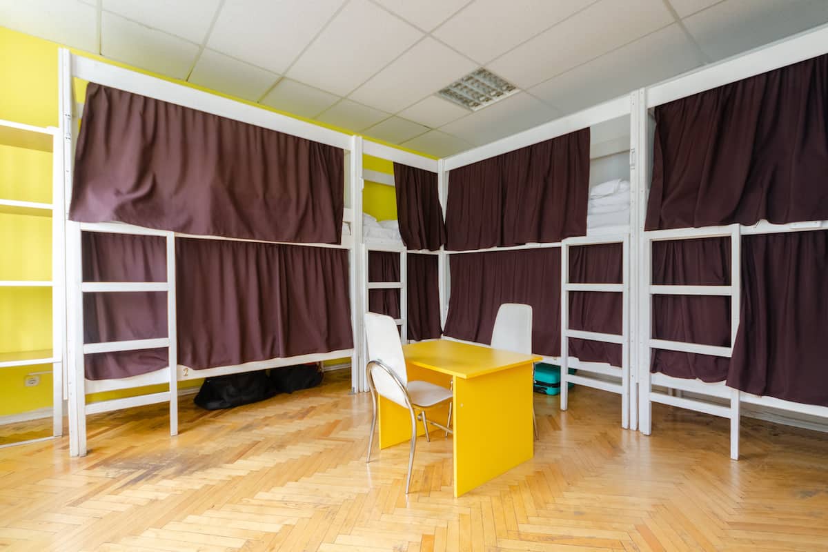 Quarto de dormitório com beliches, uma escrivaninha e uma cadeira.