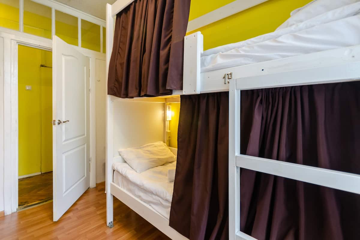 Quarto com beliche e porta de acesso a um banheiro.