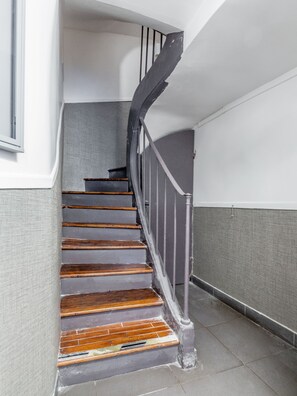 A staircase with wooden steps and metal railings, leading to an upper floor. - Résidence Louvre - Bellan (Paris)