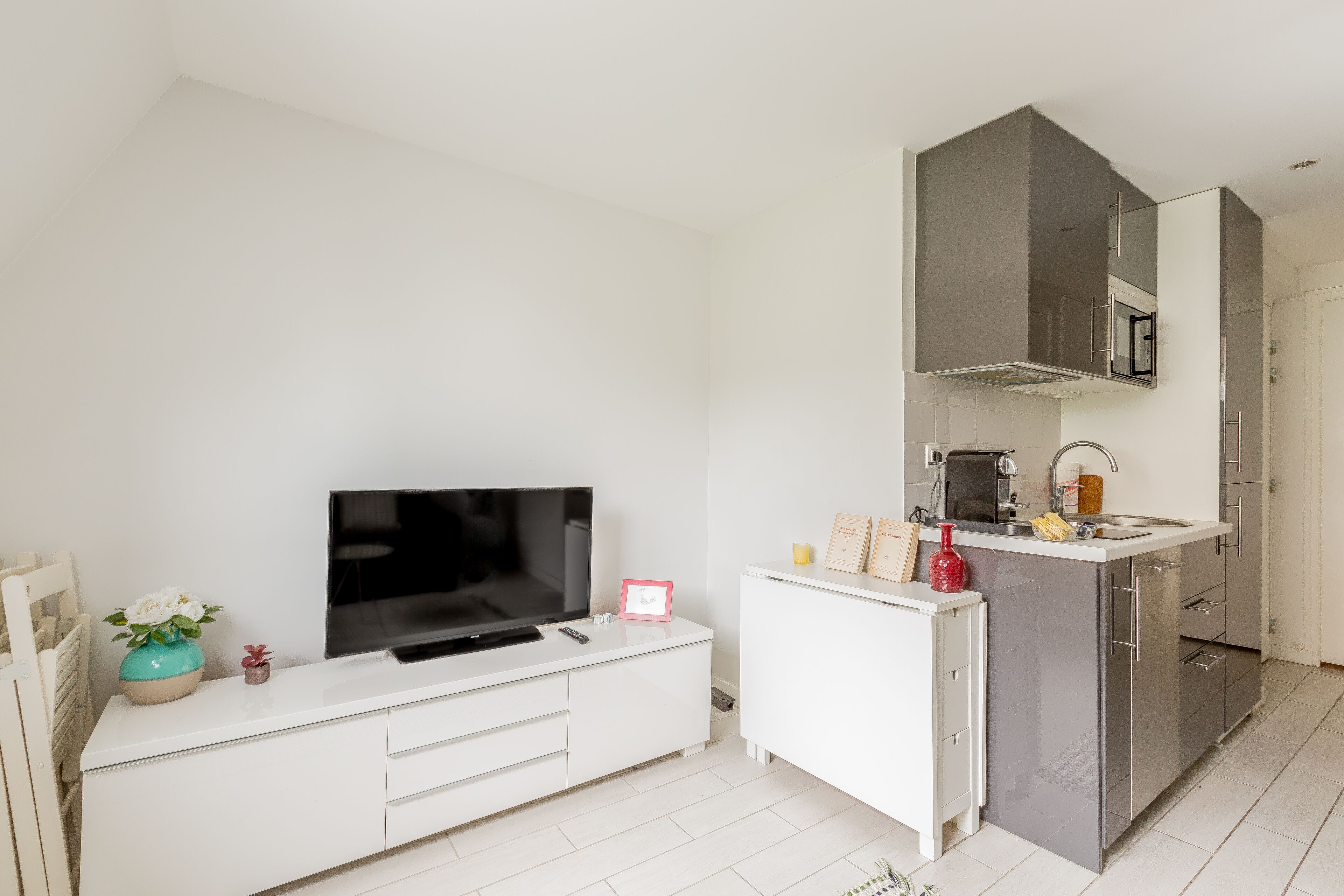 A modern kitchen with a built-in microwave, a sink, and a white countertop.