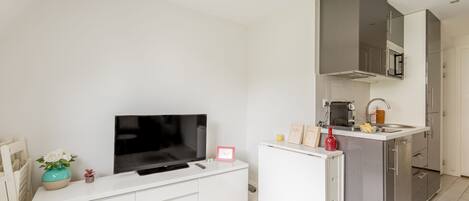 A modern kitchen with a built-in microwave, a sink, and a white countertop.