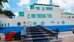 A multi-story building with a staircase leading to the upper levels. - Eden Hotel And Resorts (Ota)