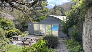 A small house with a patio, a pool, and a view of the mountains. - The Elmfield (Ilfracombe)