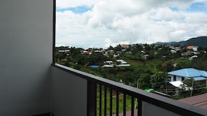 Un balcón con vistas a un pueblo y montañas.