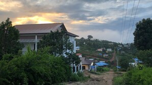 Un barrio residencial con casas, un sendero de tierra y un cielo nublado.