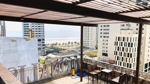 Un balcón con vista a la playa y edificios.
