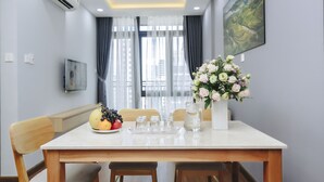 Un comedor con una mesa, sillas, un frutero, una jarra y un florero.