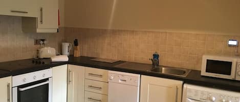 Departamento | Cocina privada | Refrigerador con congelador, microondas, horno y parrilla de estufa