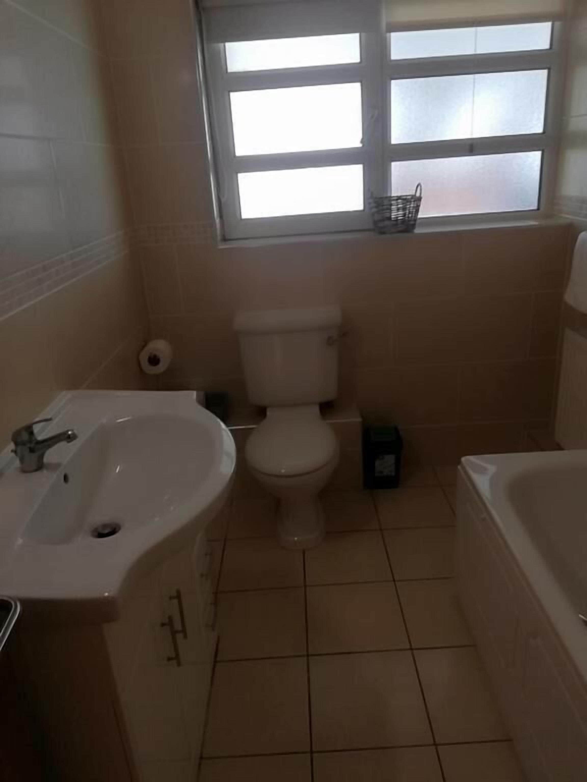 A bathroom with a toilet, sink, and bathtub.