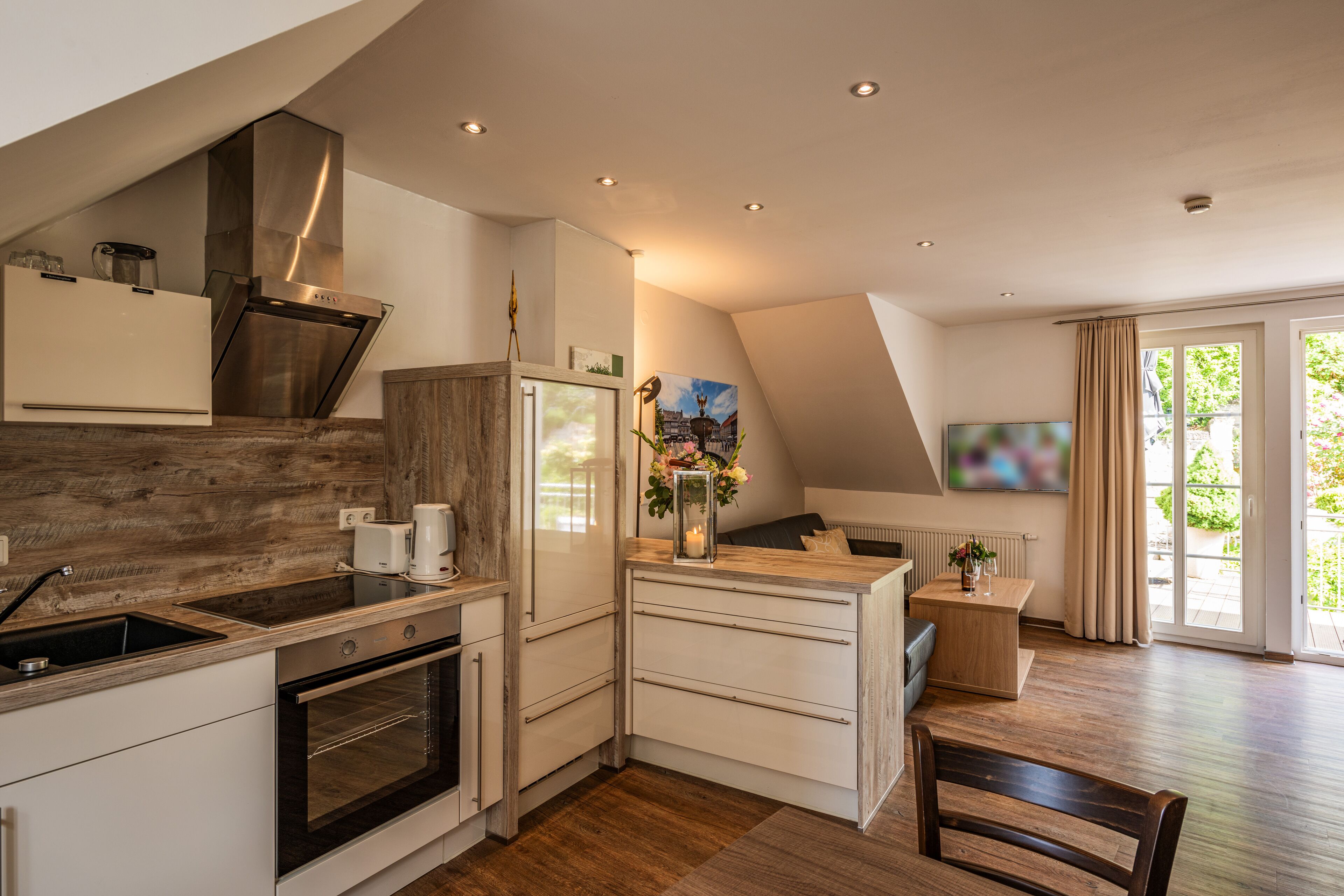 A modern kitchen with a built-in oven, a stainless steel range hood, and a wooden backsplash.