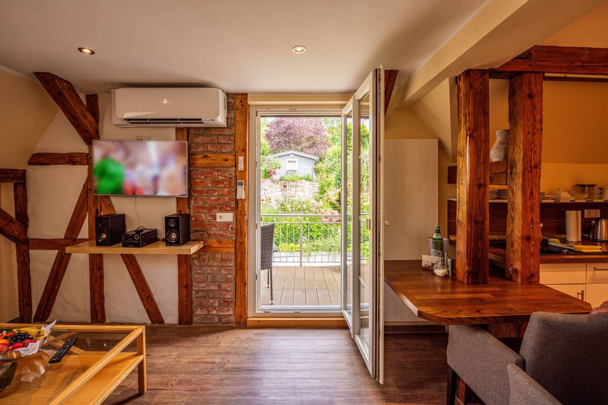 Een woonkamer met een televisie, speakers en een houten tafel.