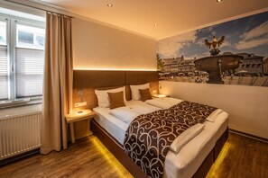 Relax in a spacious room with a large bed, two bedside tables, and a nightstand. Enjoy the view from the window with blinds, and stay cozy with the wall-mounted light fixture.