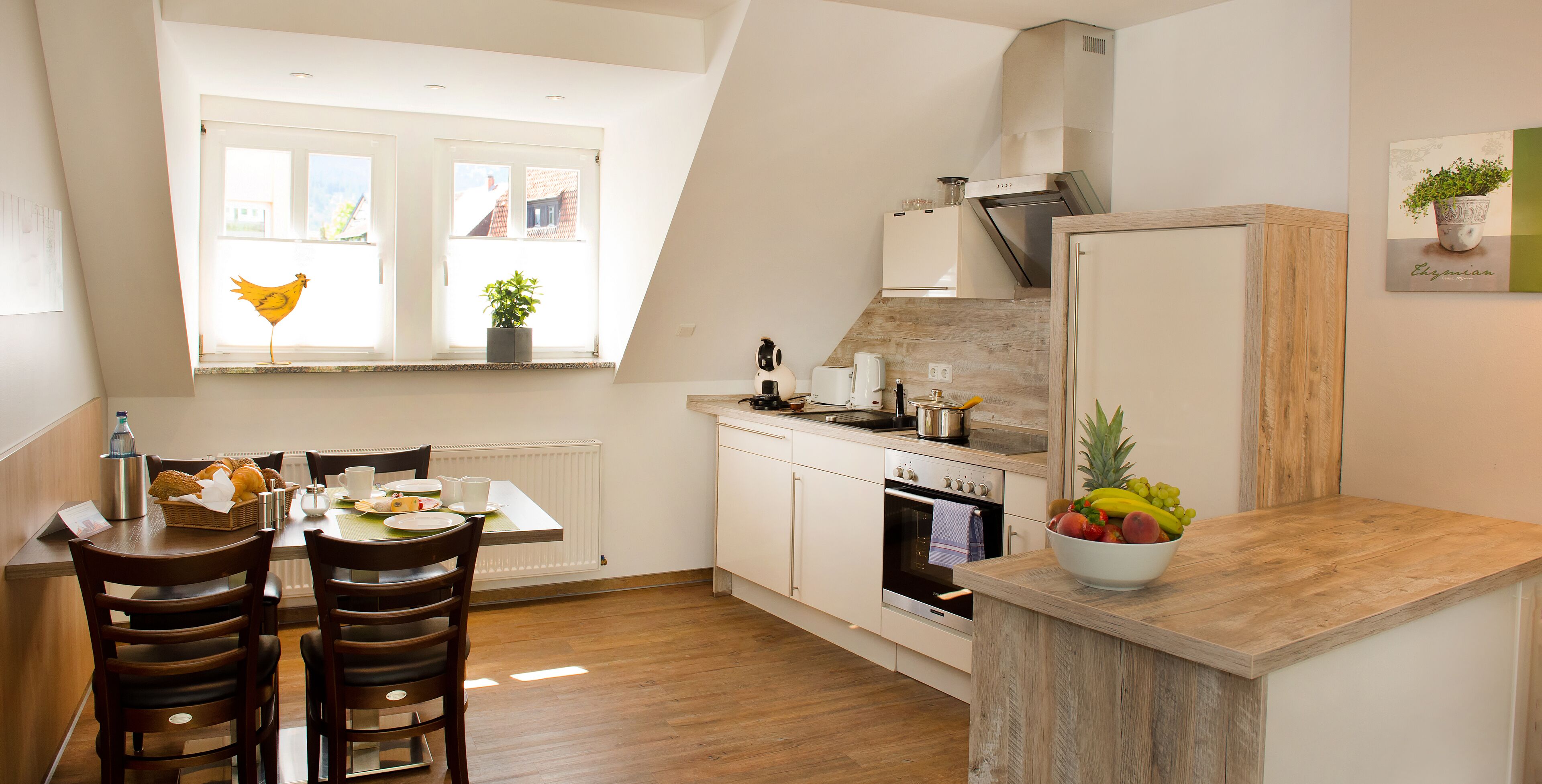 Una cocina moderna con armarios blancos, encimera de madera y un comedor con mesa y sillas.