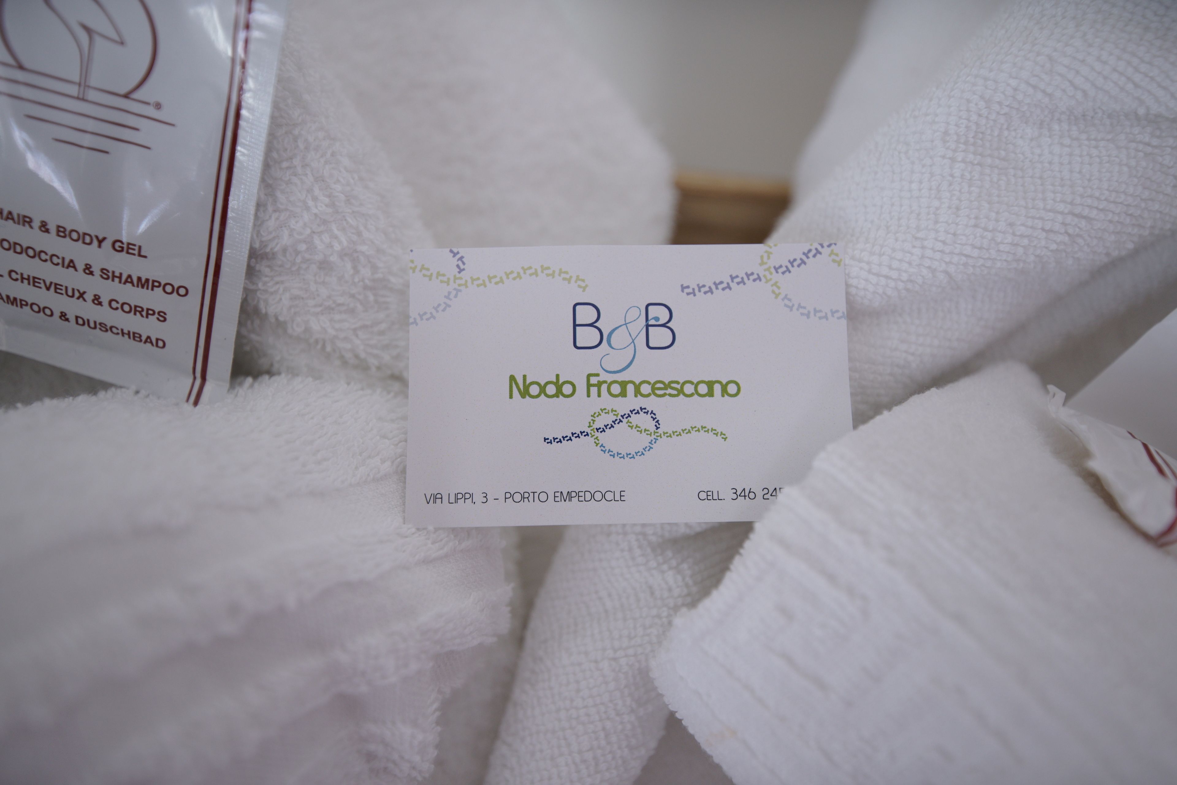Una toalla blanca con una etiqueta que dice "B&B Nono Francescano" y un número de teléfono.