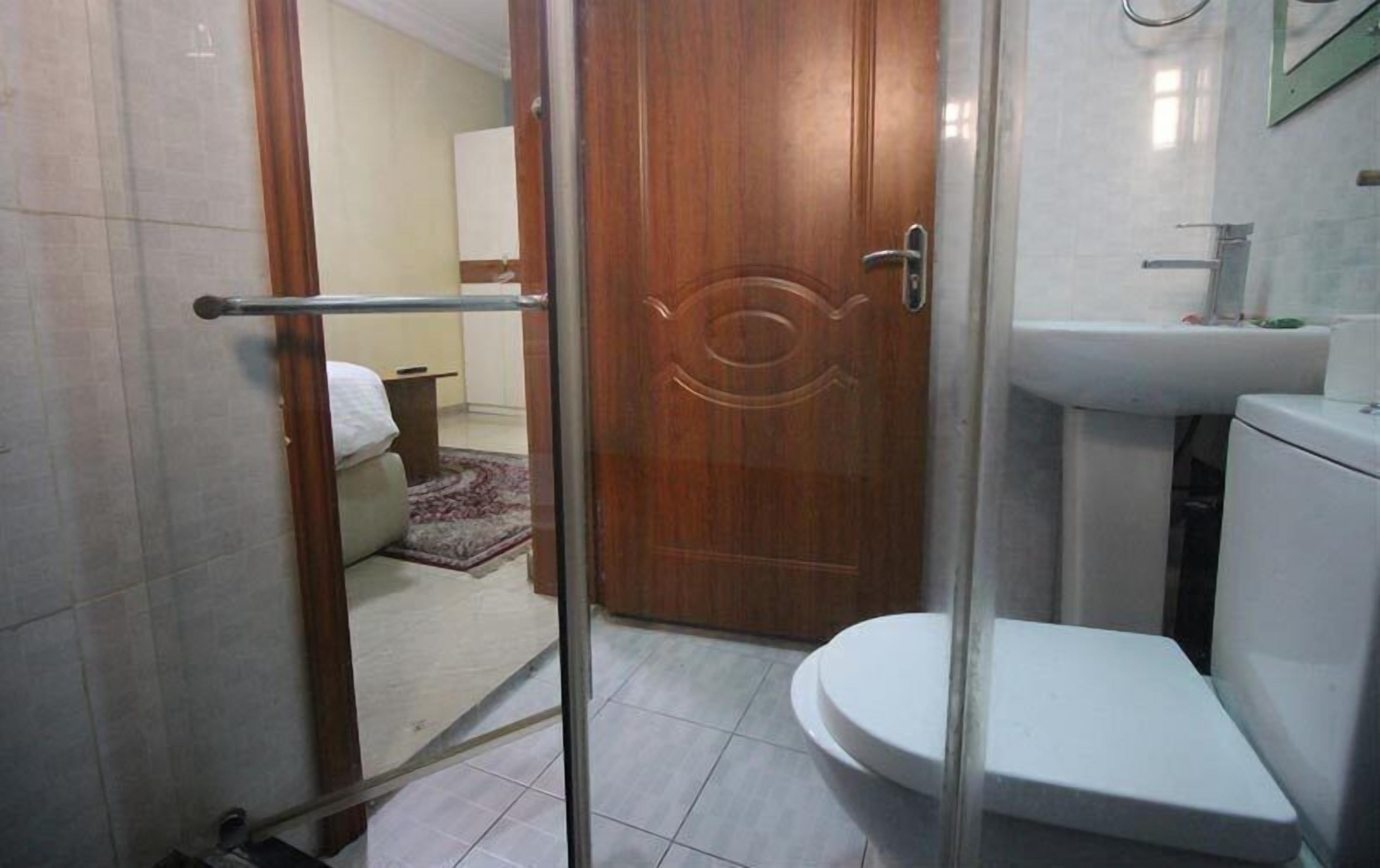 A bathroom with a toilet, sink, and shower area.