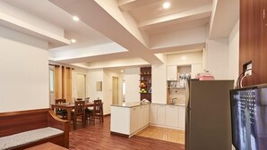 Une cuisine compacte avec un coin repas, un plancher en bois et un réfrigérateur encastré.