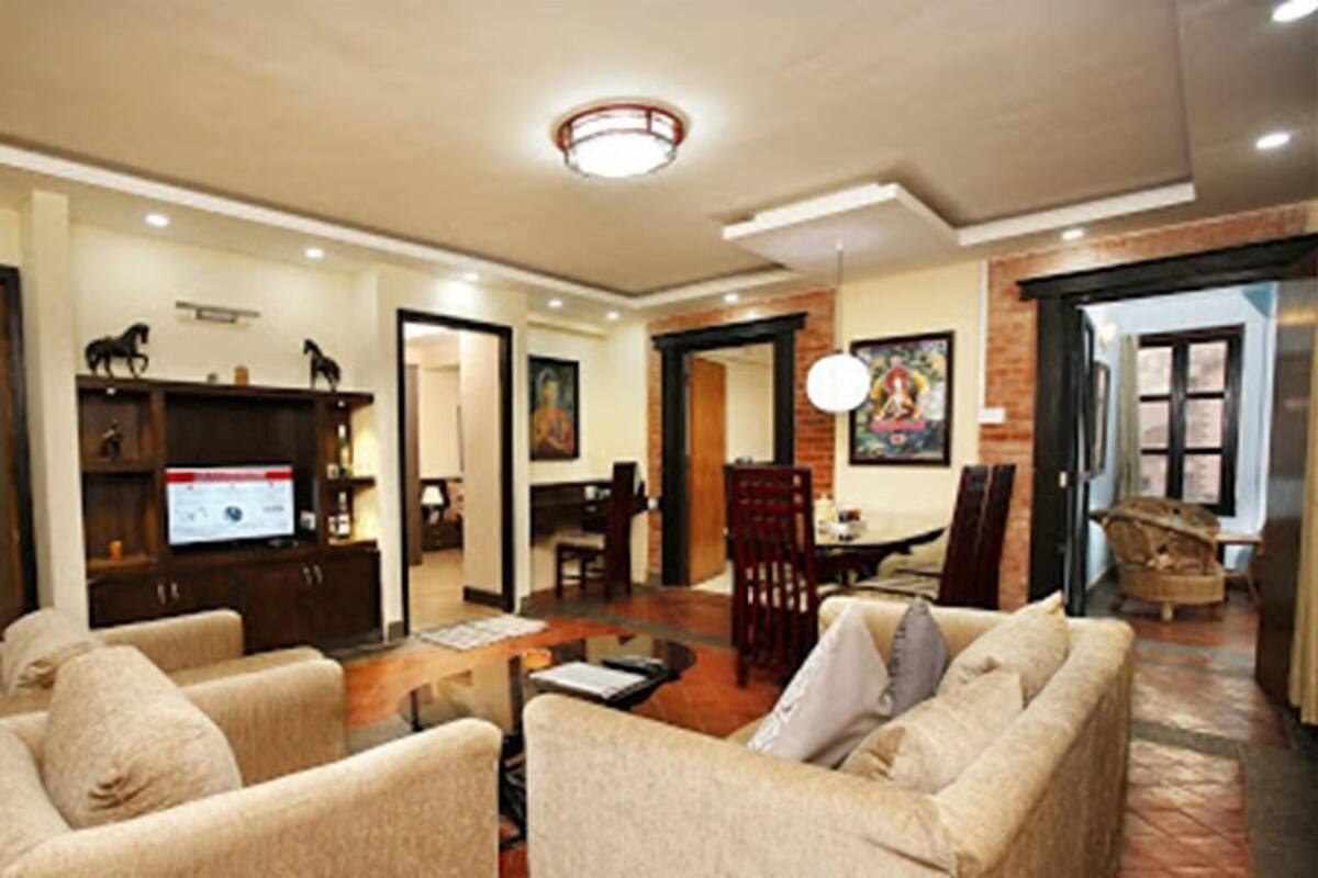 A spacious living room with a fireplace, a television, and a dining area.