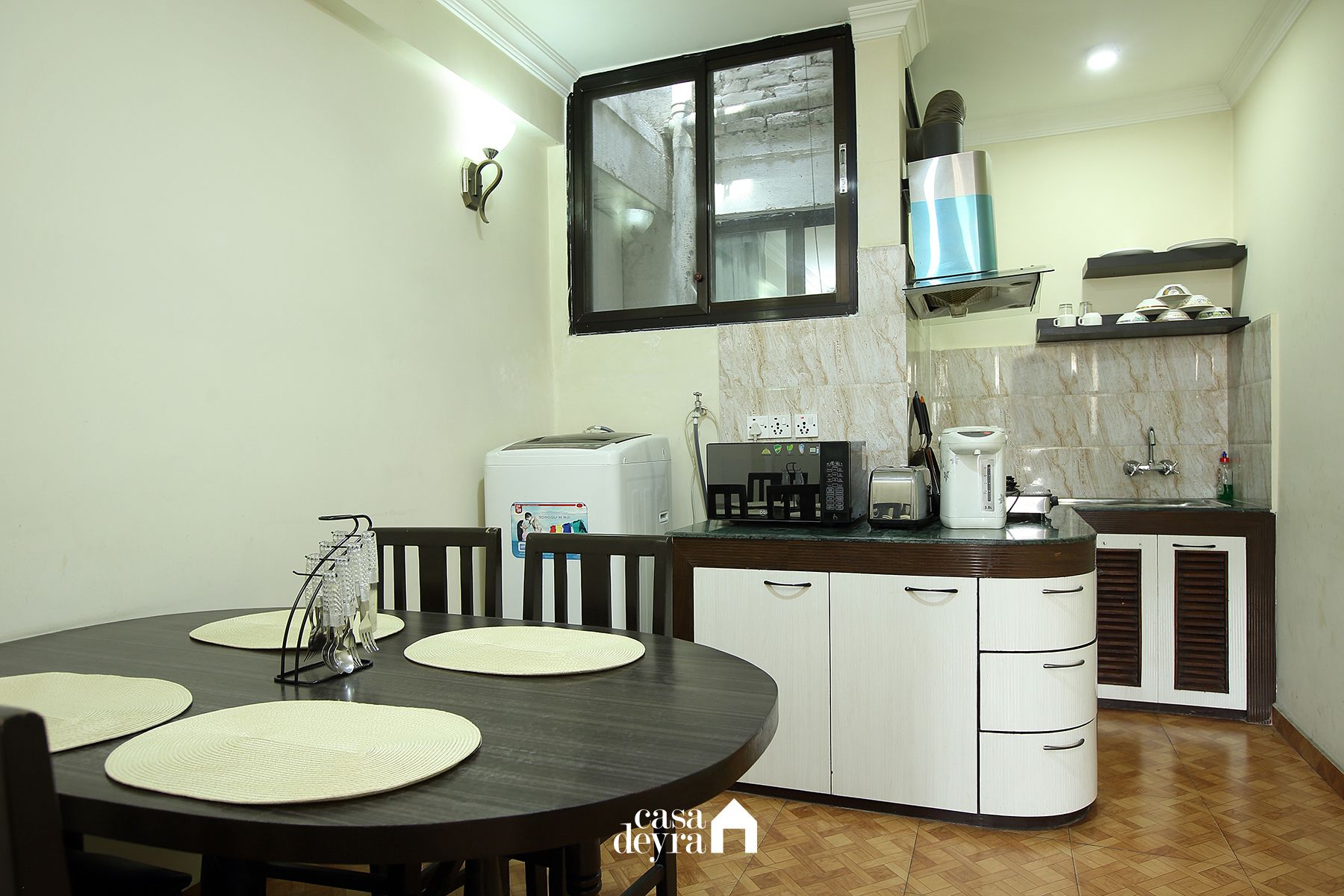 A compact kitchen with a dining area, featuring a microwave, toaster, and coffee maker.
