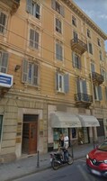 Un edificio de varios pisos con fachada amarilla, un letrero que dice 'Restaurant Center' y una tienda con toldos.