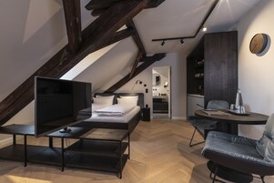 Quarto de loft moderno com uma cama grande, uma TV e um espaço de jantar com mesa e cadeiras.