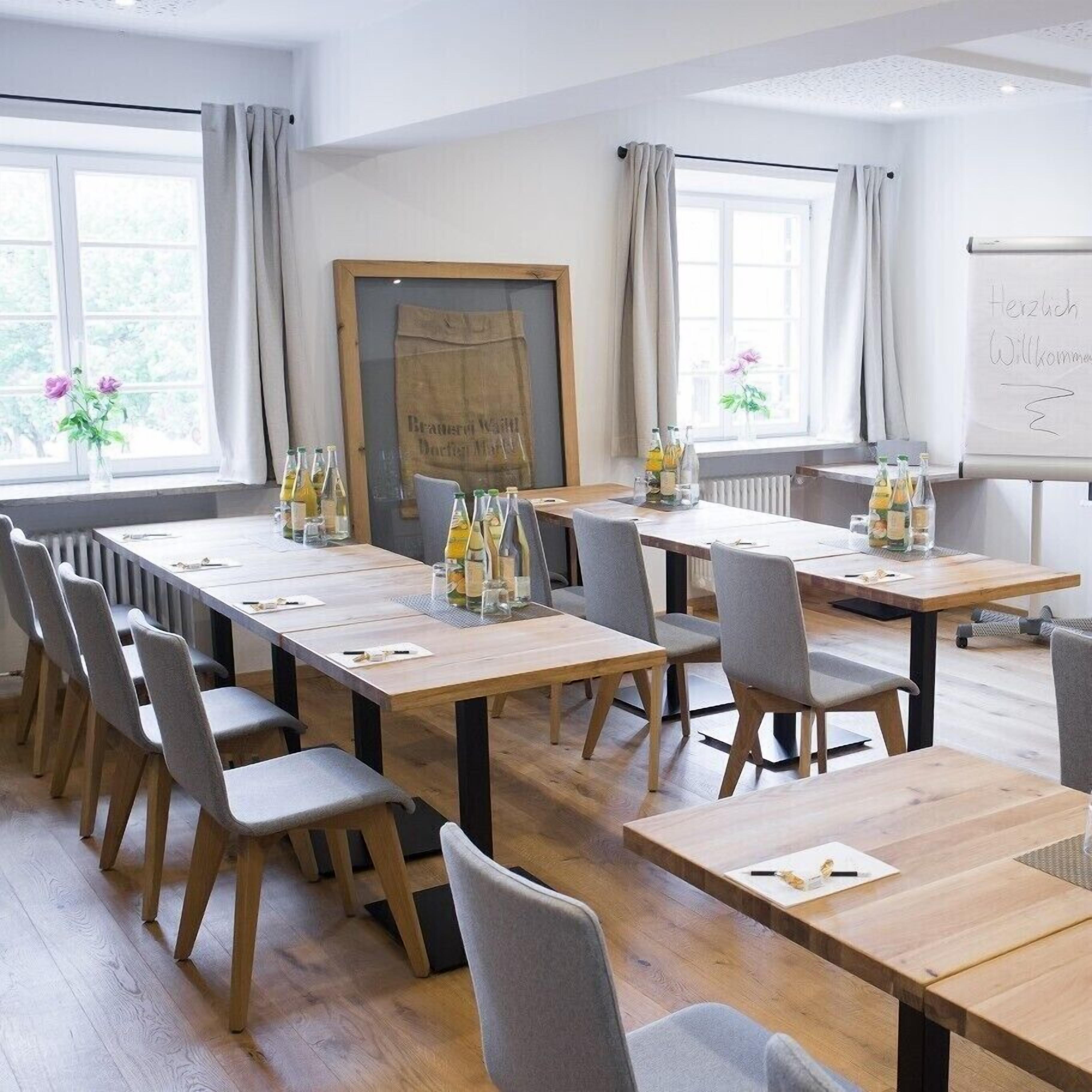 A conference room with long tables, chairs, and a whiteboard.
