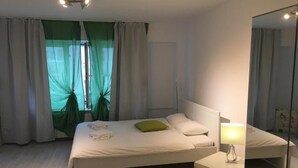 Une chambre à coucher moderne avec un lit, une table de chevet et un miroir.