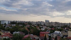 Un paysage urbain avec des immeubles d’habitation, dont certains ont des toits rouges, et quelques bâtiments de grande hauteur.