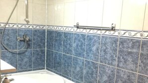 Une salle de bain avec une baignoire, une douche et des toilettes.