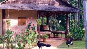A rustic wooden structure with a brick wall and a covered patio area. - Atta Rainforest Lodge (Mauisparu)