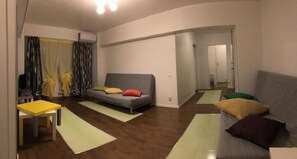 A modern living room with a sofa, a small table, and a mirror. - New Central Roof Top (Bucharest)