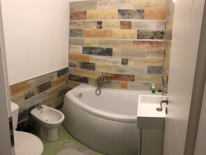 A bathroom with a bathtub, a sink, and a bidet. - New Central Roof Top (Bucharest)
