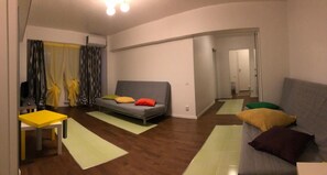 A modern living room with a sofa, a small table, and a mirror. - New Central Roof Top (Bucharest)