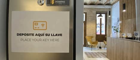 Un mostrador de recepción con un cartel que indica dónde dejar las llaves.