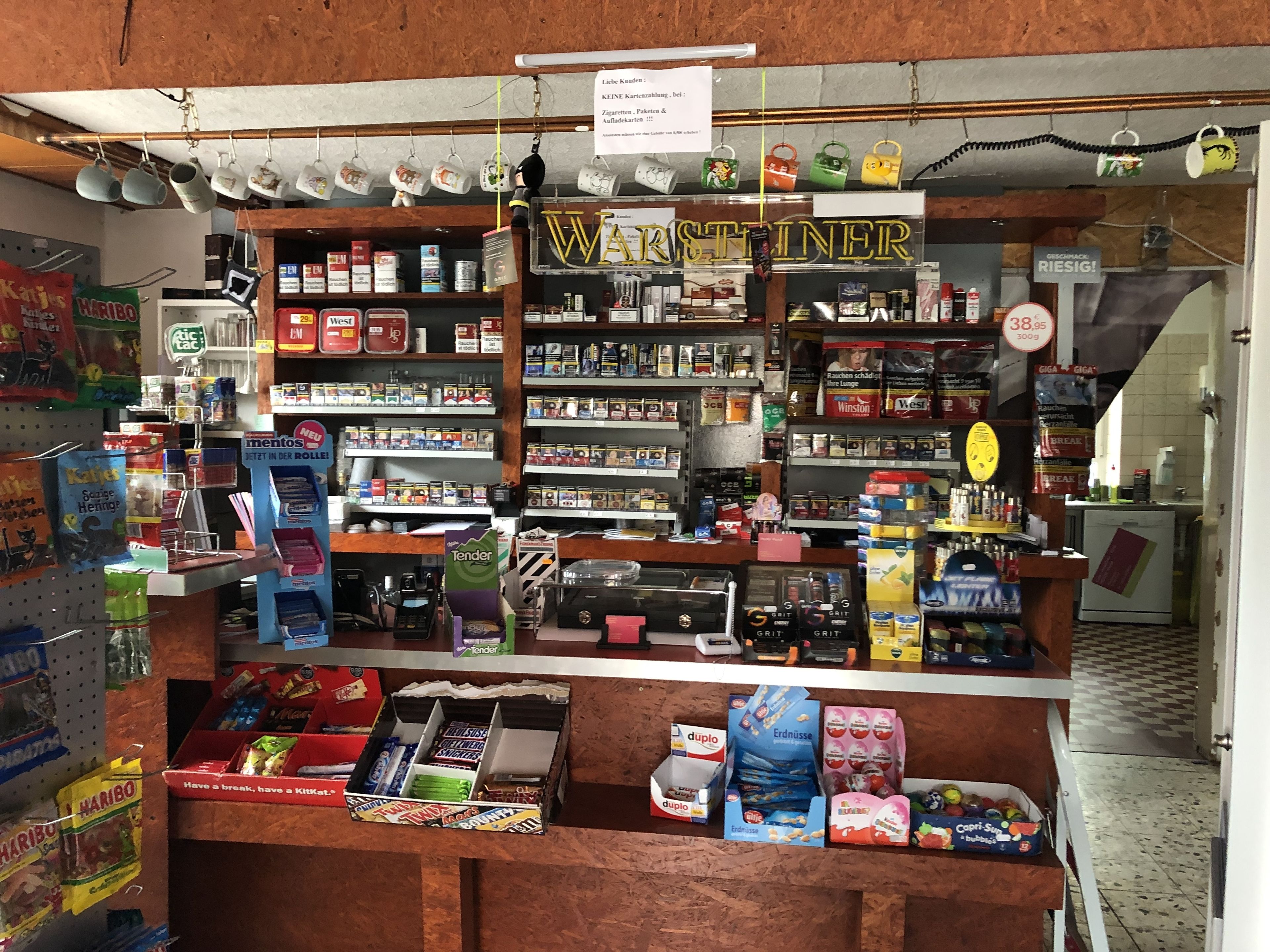 A small convenience store with shelves stocked with snacks, cigarettes, and other items.