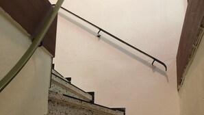 A staircase with speckled steps and black handrails, leading upwards. - Hostel Wendt (Fintel)