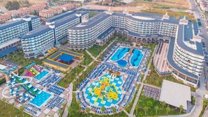 A resort with multiple hotel buildings, a central pool area with a water slide, and a large outdoor pool. - Eftalia Ocean Resort and Spa (Alanya)