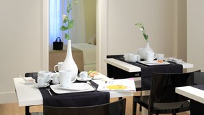 Ein Restaurantbereich eines Hotels mit gedeckten Tischen für das Frühstück, einschließlich Tellern, Tassen und einer Speisekarte.