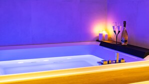 Eine Badewanne mit Kerzen und einer Champagnerflasche.