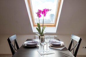Une table à manger avec deux chaises, une plante en pot et deux verres à vin.