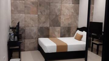 Un dormitorio con cama, mesita de noche, espejo y ventilador de techo.