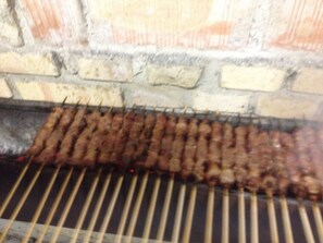 Una parrilla con brochetas de carne.