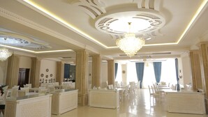 A luxurious hotel lobby with ornate ceiling designs, chandeliers, and a spacious seating area. - Orient Star Varaxsha (Bukhara)