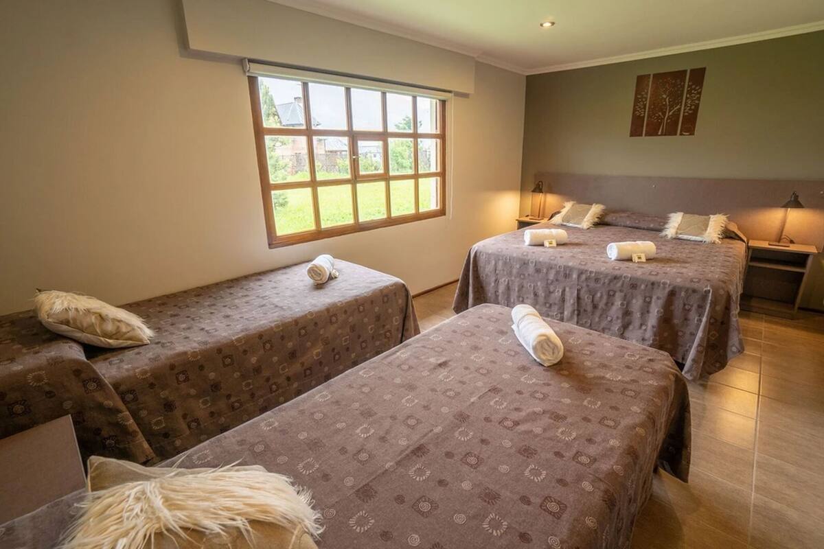 Une chambre d’hôtel avec deux lits simples, une grande fenêtre et une vue sur l’extérieur.